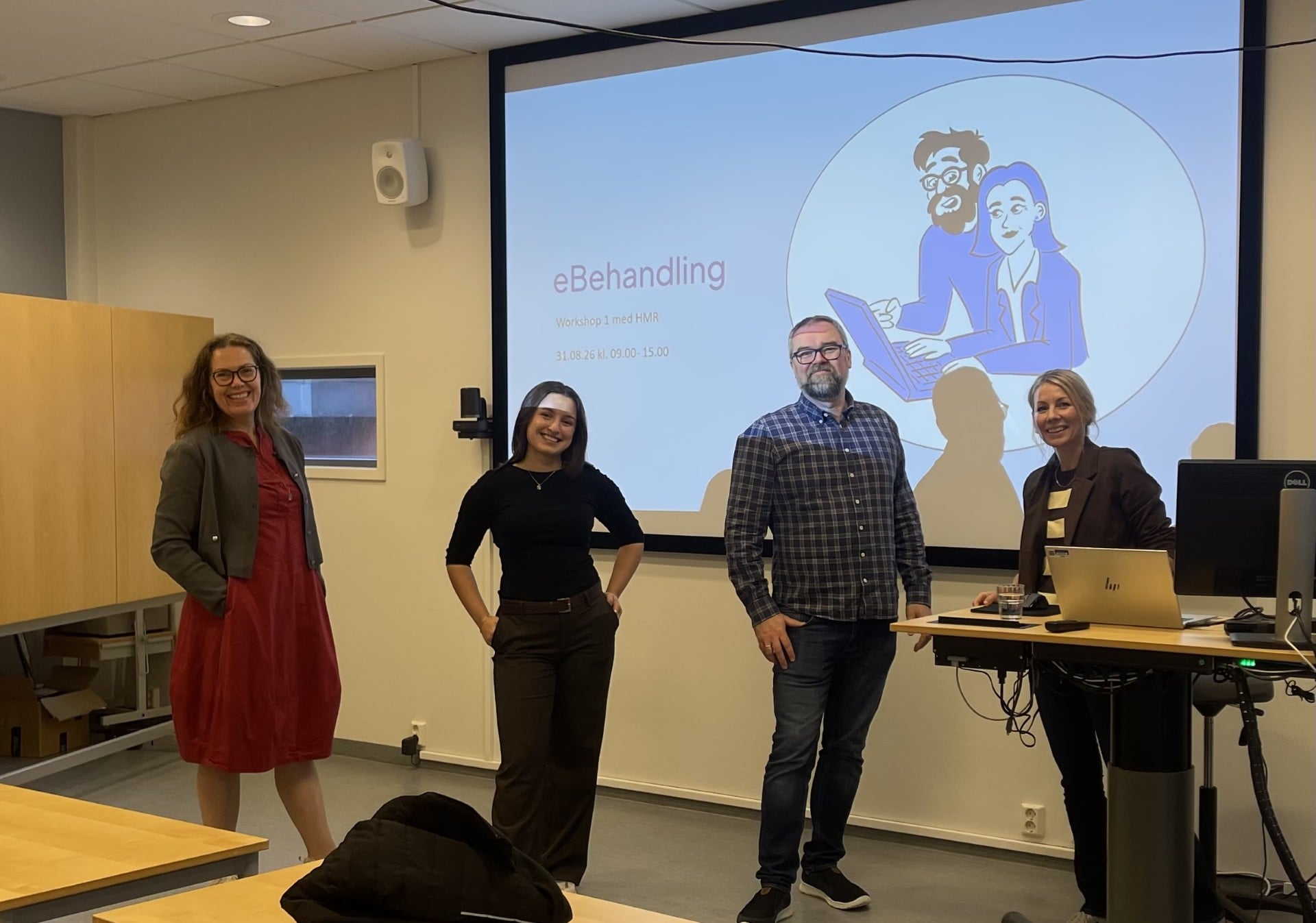 Fire personar frå det regionale samarbeidet som står forran ein presentasjon om eBehandling. 
