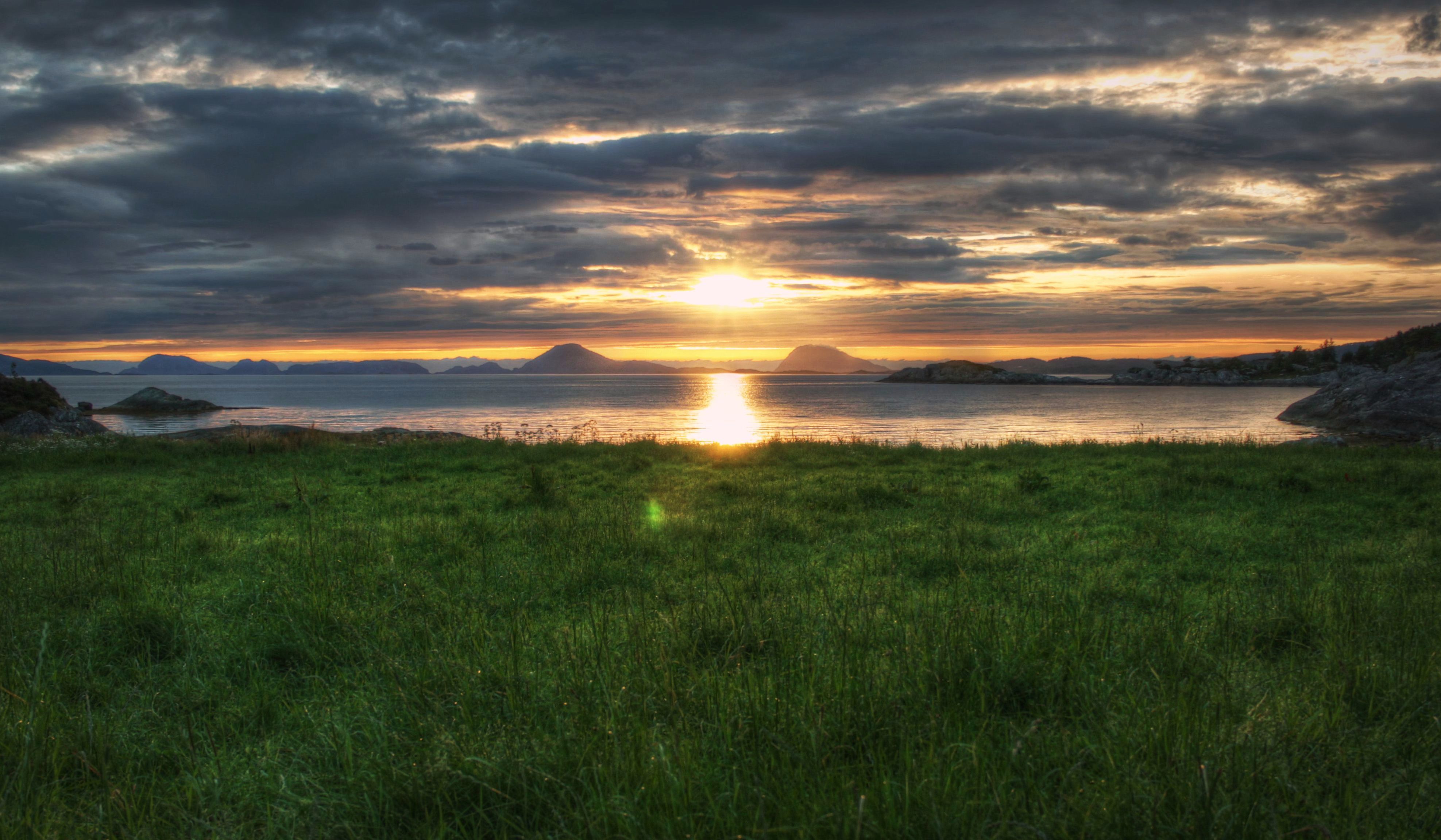 En gresskledd eng med solnedgangen