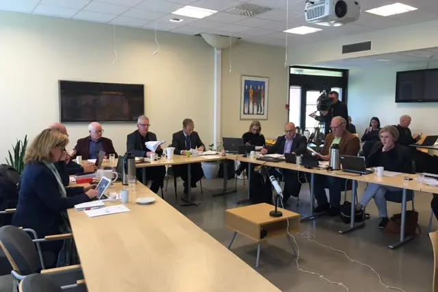 En gruppe mennesker som sitter ved bordene