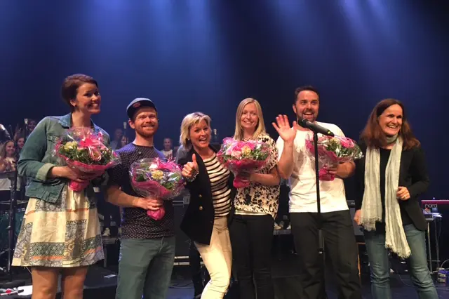 En gruppe mennesker som holder blomster