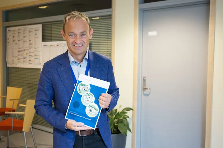 Adm.dir i Helse Møre og Romsdal, Espen Remme, med konseptrapporten for SNR.
