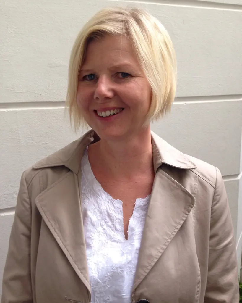 En kvinne som smiler til kameraet