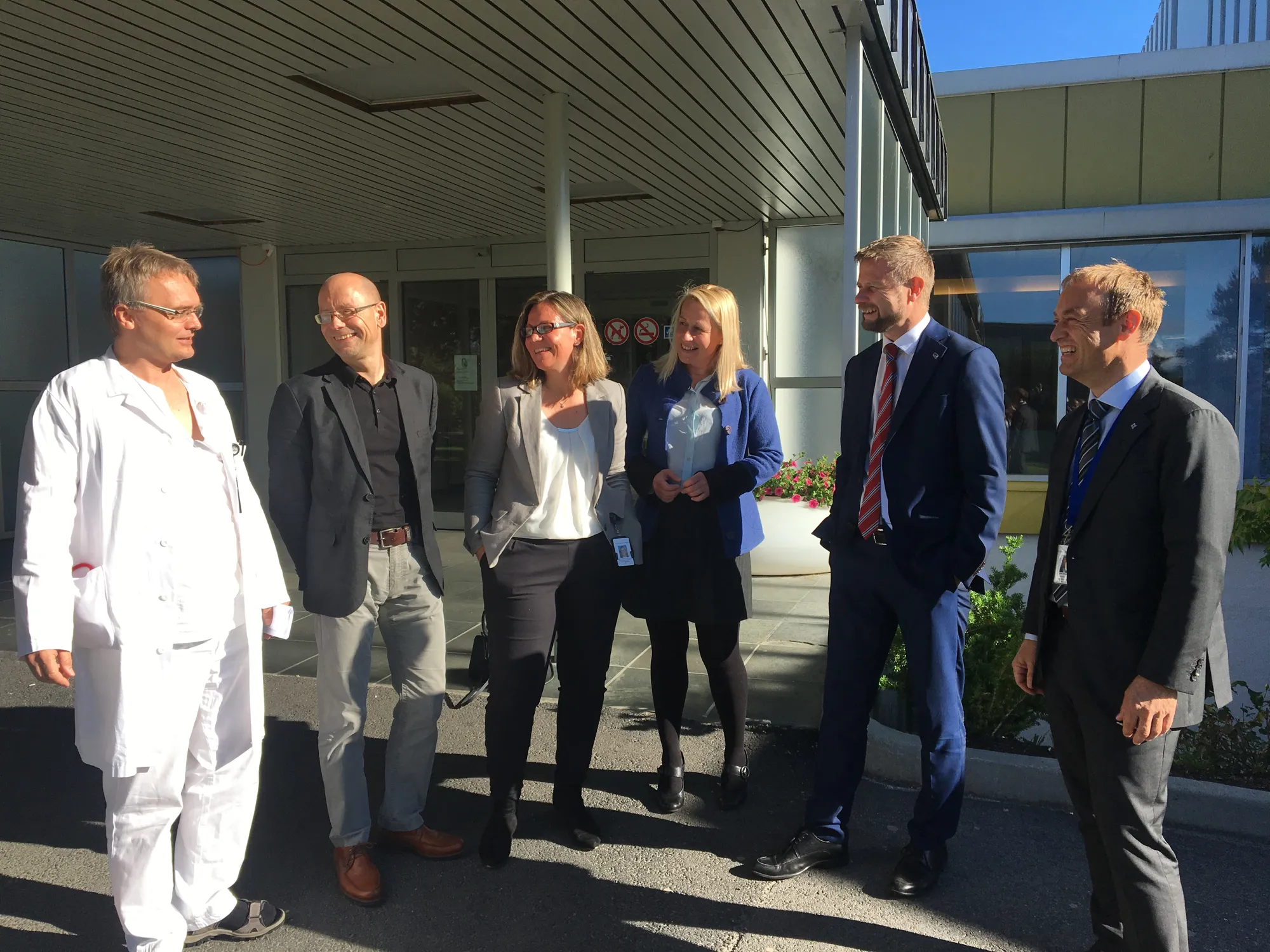 En gruppe mennesker som står utenfor en bygning