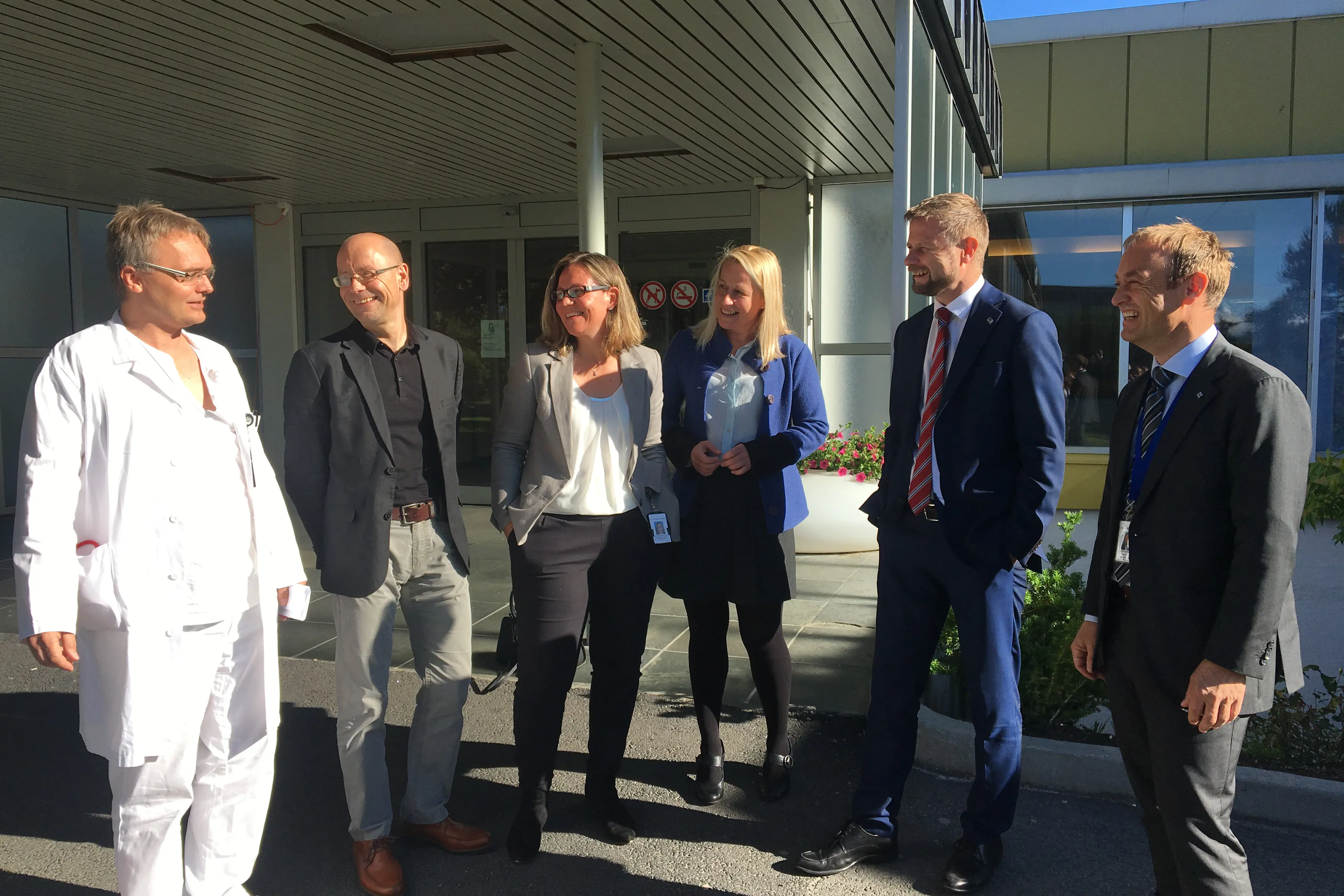 En gruppe mennesker som står utenfor en bygning