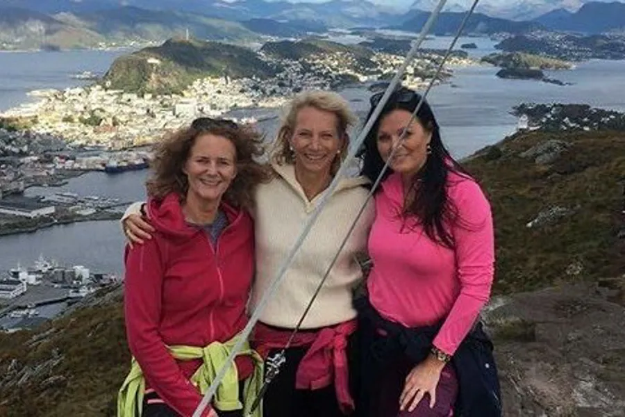 En gruppe kvinner som poserer for et bilde på et fjell