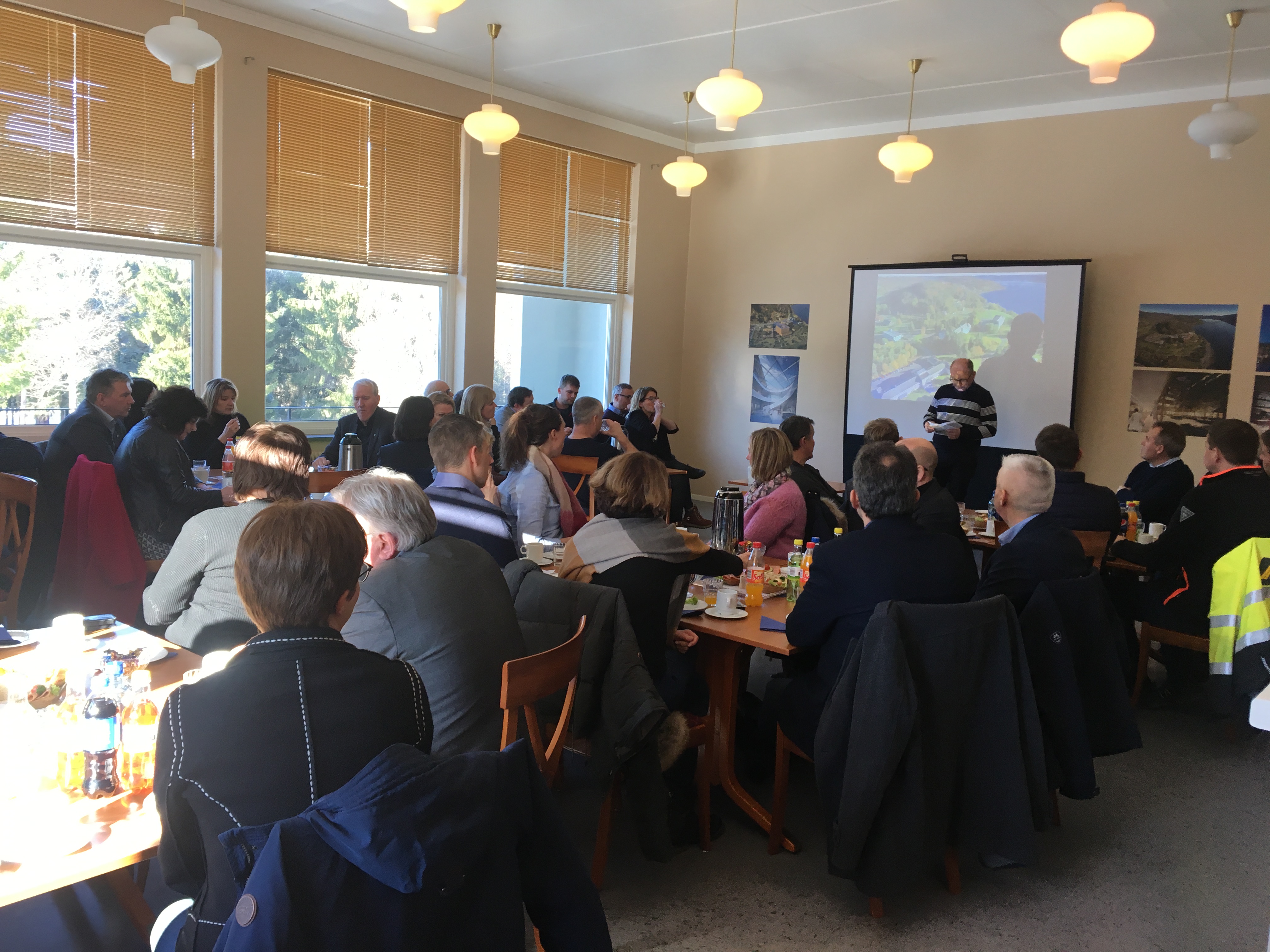 En gruppe mennesker som sitter ved bordene