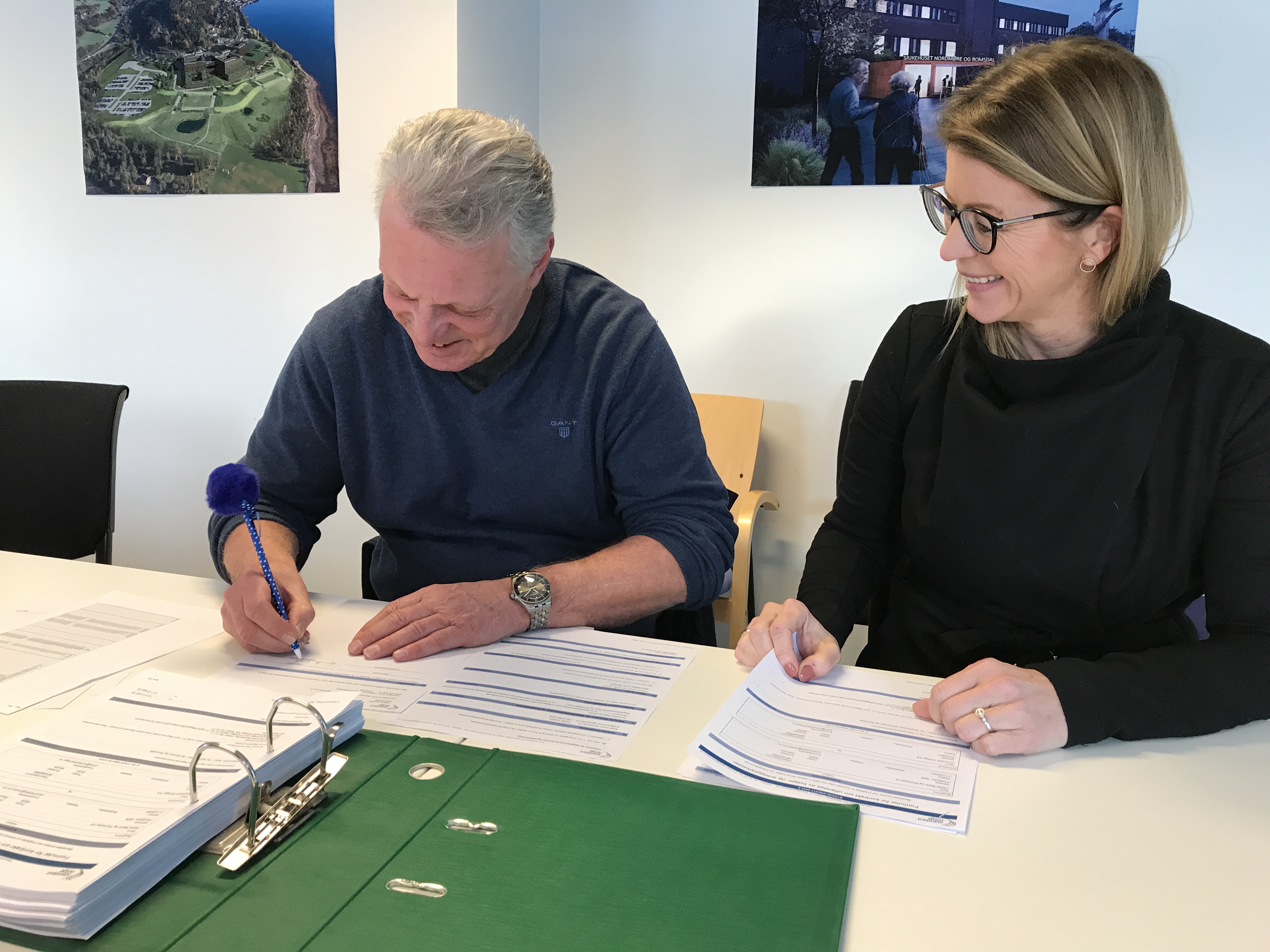 En mann og en kvinne som ser på papirer på et bord