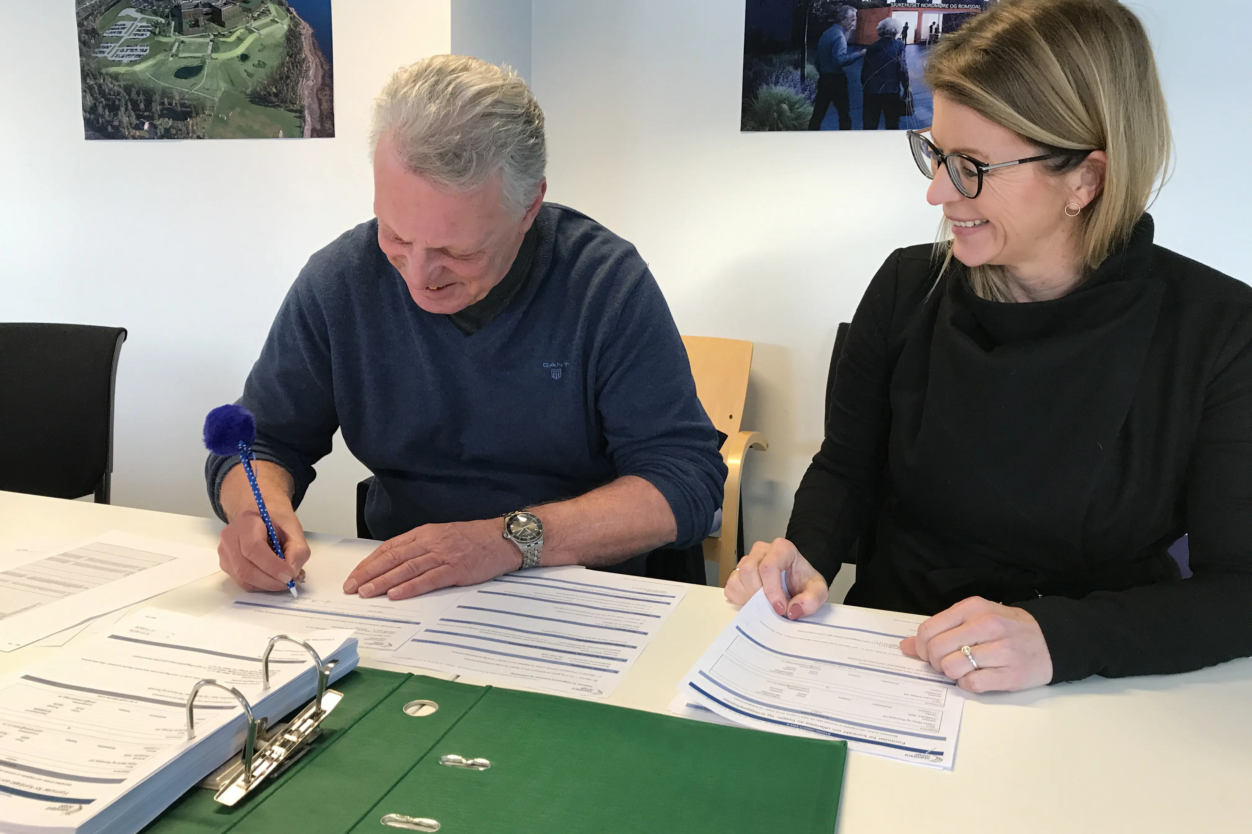 En mann og en kvinne som ser på papirer på et bord