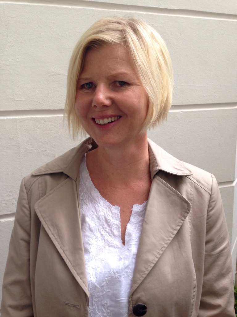 En kvinne som smiler til kameraet