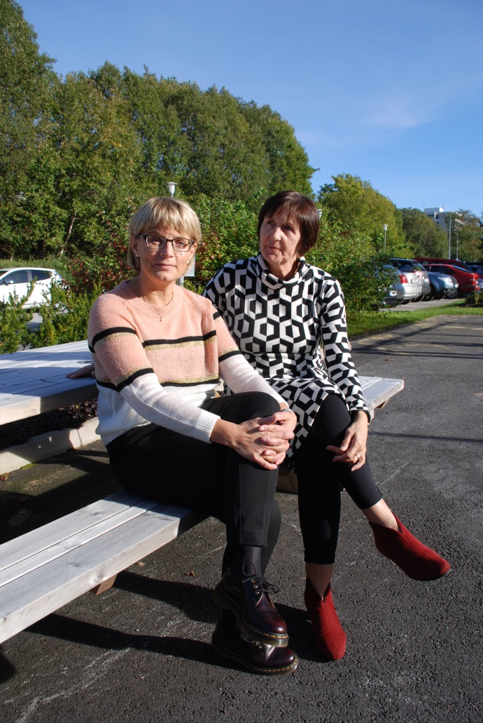 To kvinner som sitter på en benk