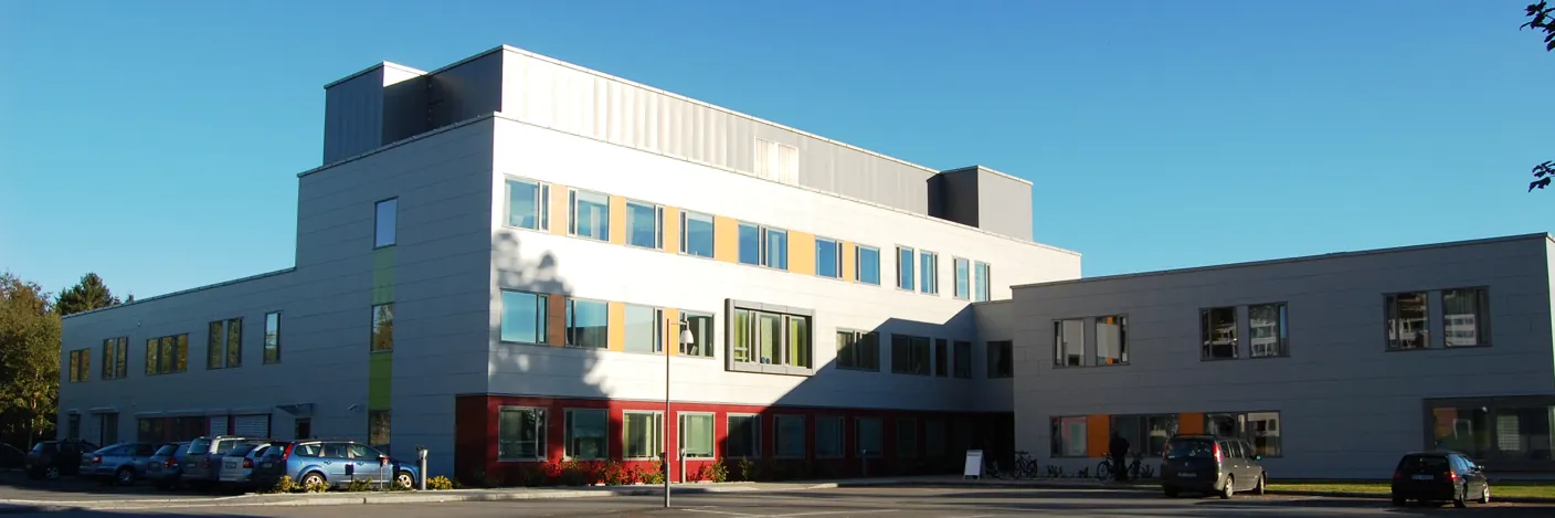 En bygning med biler parkert foran