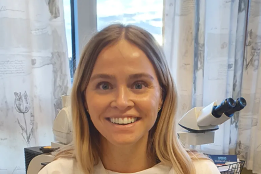 En kvinne som smiler foran en mikrofon