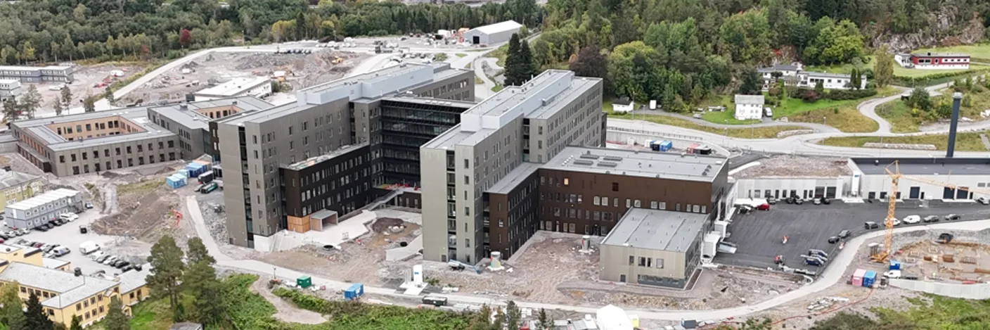 Dronebilde av Sjukehuset Nordmøre og Romsdal, Hjelset. Eit sjukehus ved fjorden. Arbeid med uteområdet gjenstår.
