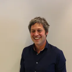 En mann som smiler til kameraet