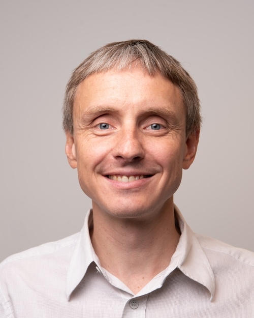 En mann som smiler til kameraet