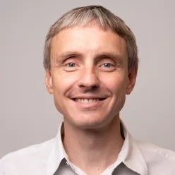 En mann som smiler til kameraet