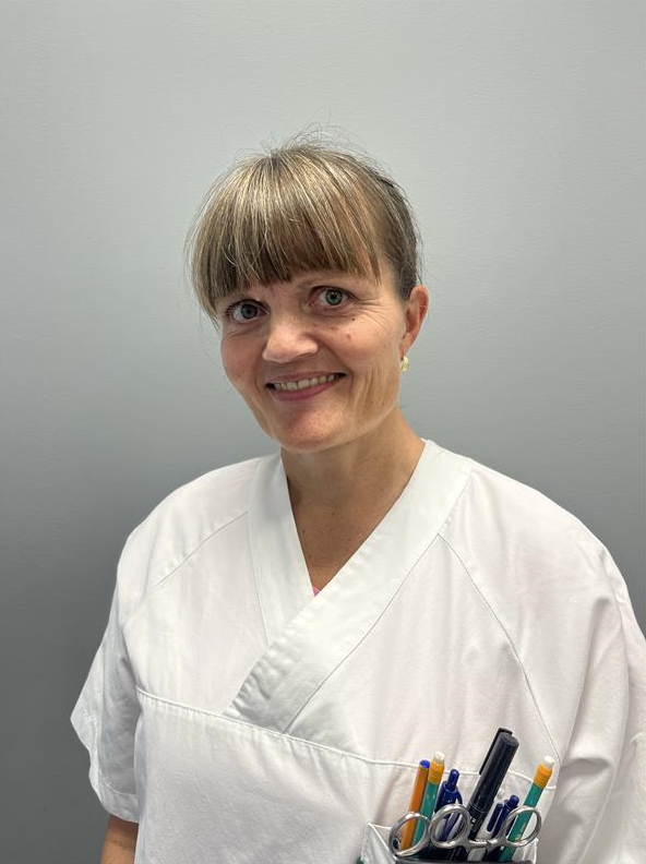 En person som smiler med en hvit skjorte