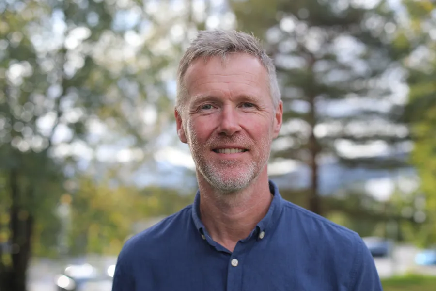 En mann som smiler til kameraet