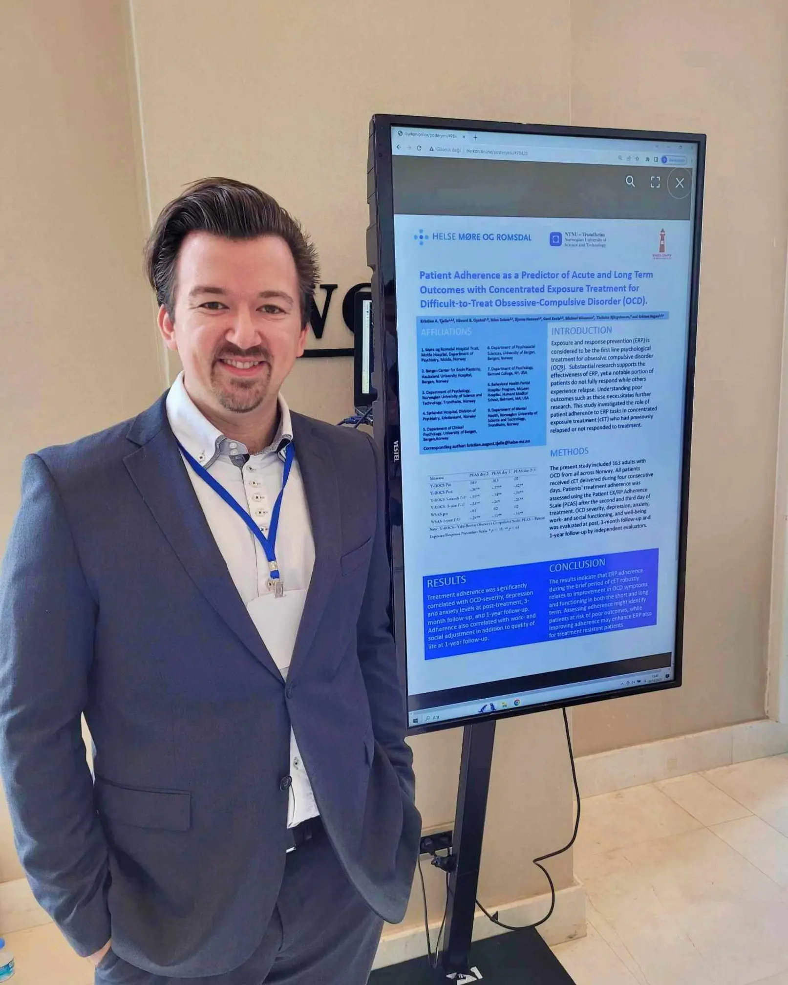 En mann som står ved siden av en stor skjerm