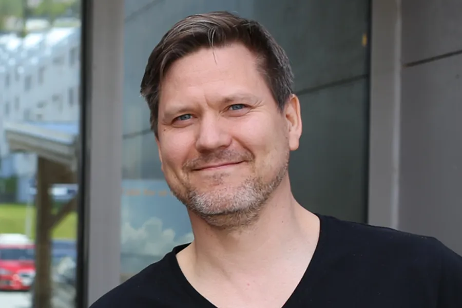 En mann som smiler til kameraet