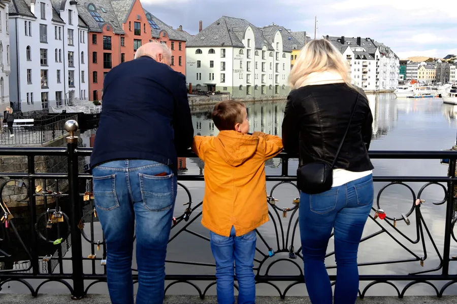 En gruppe mennesker som står på en bro over vann