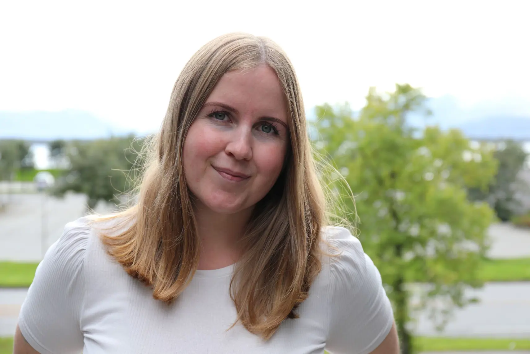 En kvinne som smiler til kameraet