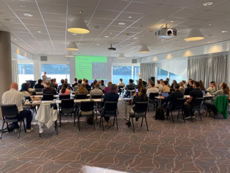 En gruppe mennesker som sitter ved bordene
