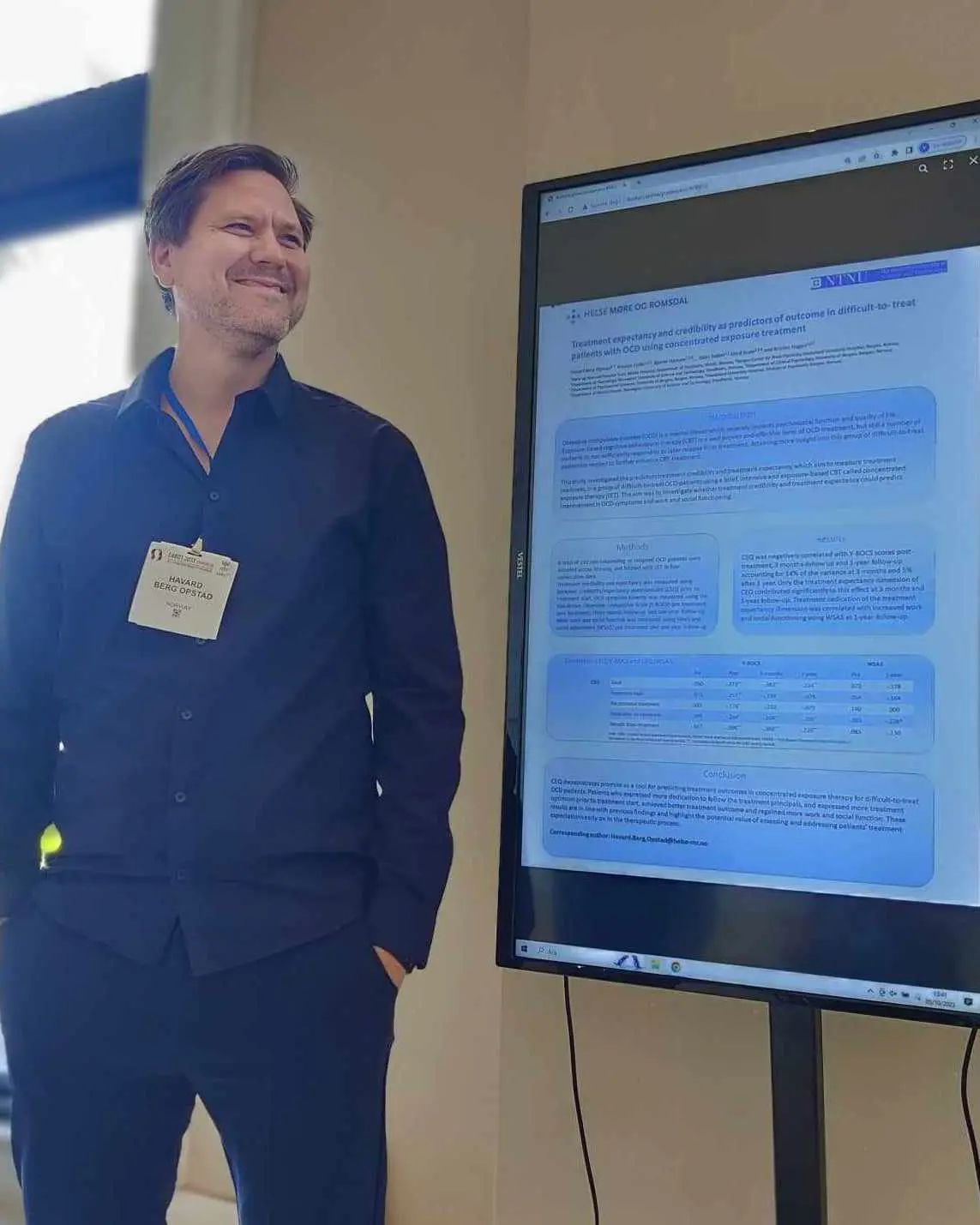 En mann som står ved siden av en stor skjerm