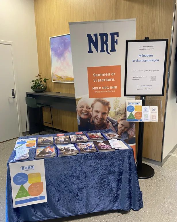 Et bord med et skilt og et par menn på