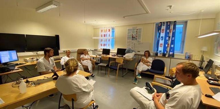 En gruppe mennesker som sitter i et rom med datamaskiner