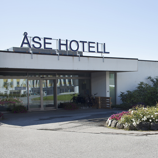 Inngangsparti med store bokstaver "ÅSE HOTELL" på taket.