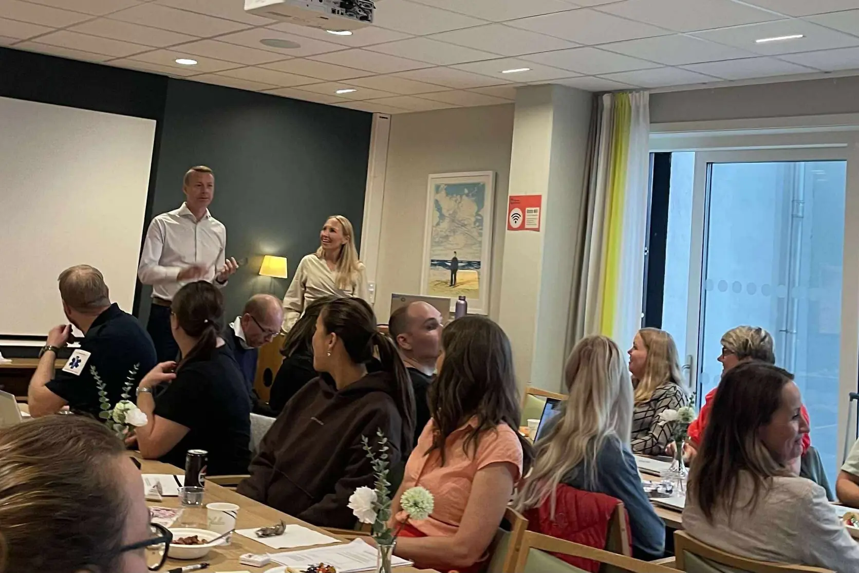 14 av deltagerne rundt bordene på felles dag for simulering av pasientforløp.