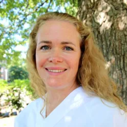 En kvinne som smiler til kameraet