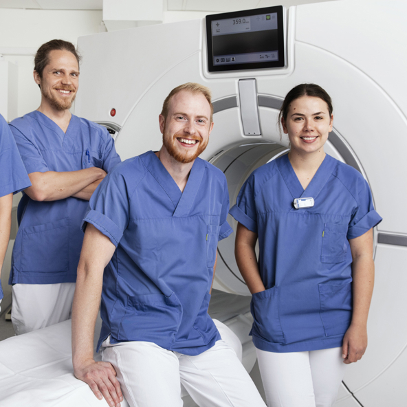 Fire kollegaer som smiler til kameraet