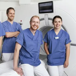 Fire kollegaer som smiler til kameraet