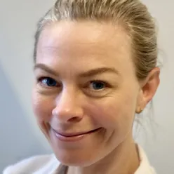 Et nærbilde av en smilende person