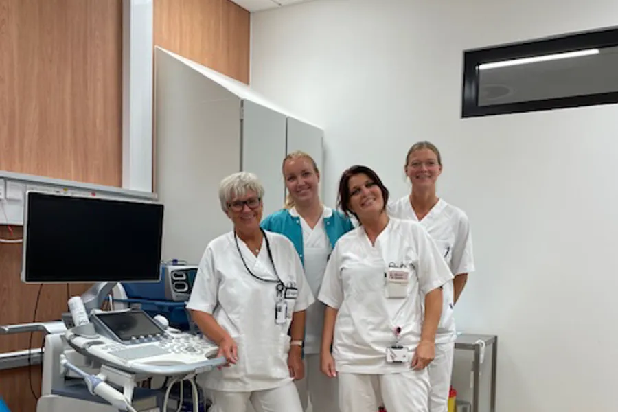 En gruppe kvinner i sykehustøy som står ved behandlingshjelpemidler på gynekologisk poliklinikk.