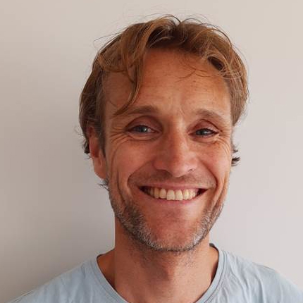 En mann som smiler til kameraet