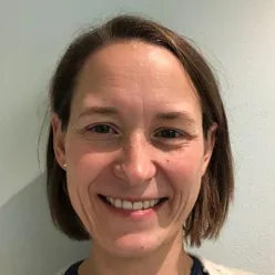 En kvinne som smiler til kameraet