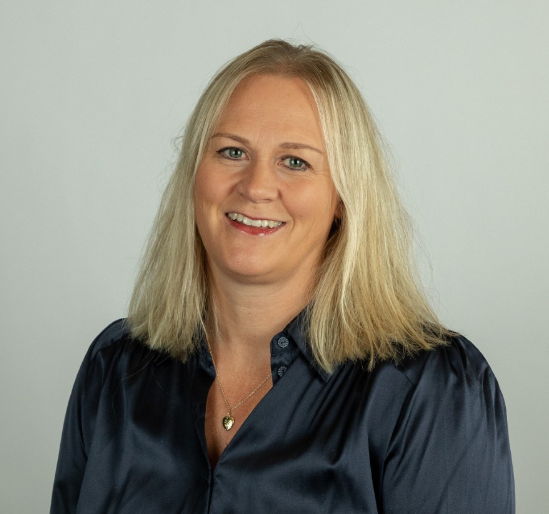 En kvinne som smiler til kameraet