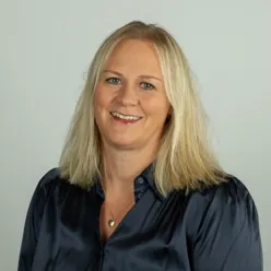 En kvinne som smiler til kameraet