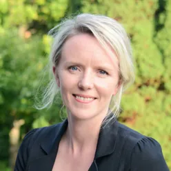 En kvinne som smiler til kameraet