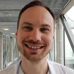 En mann som smiler til kameraet