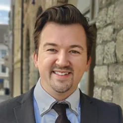 En mann som smiler til kameraet