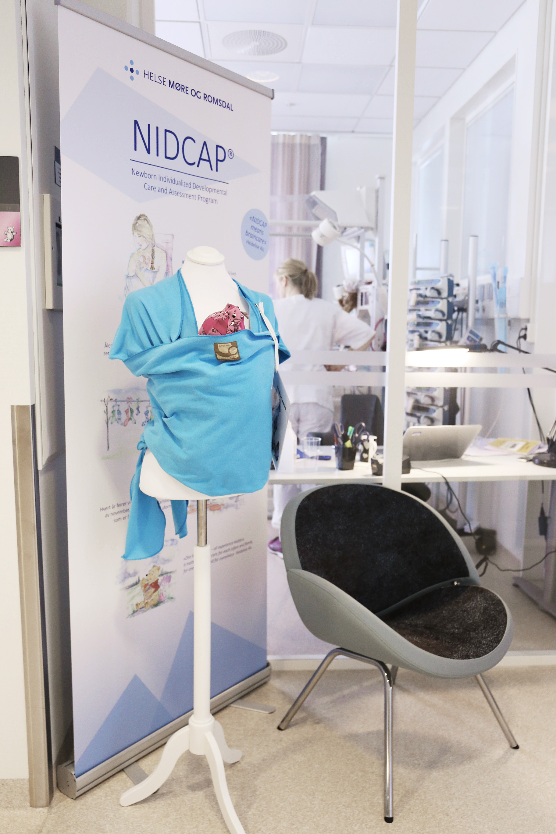 En utstillingsdukke med bæresjal for hud-mot-hud kontakt.