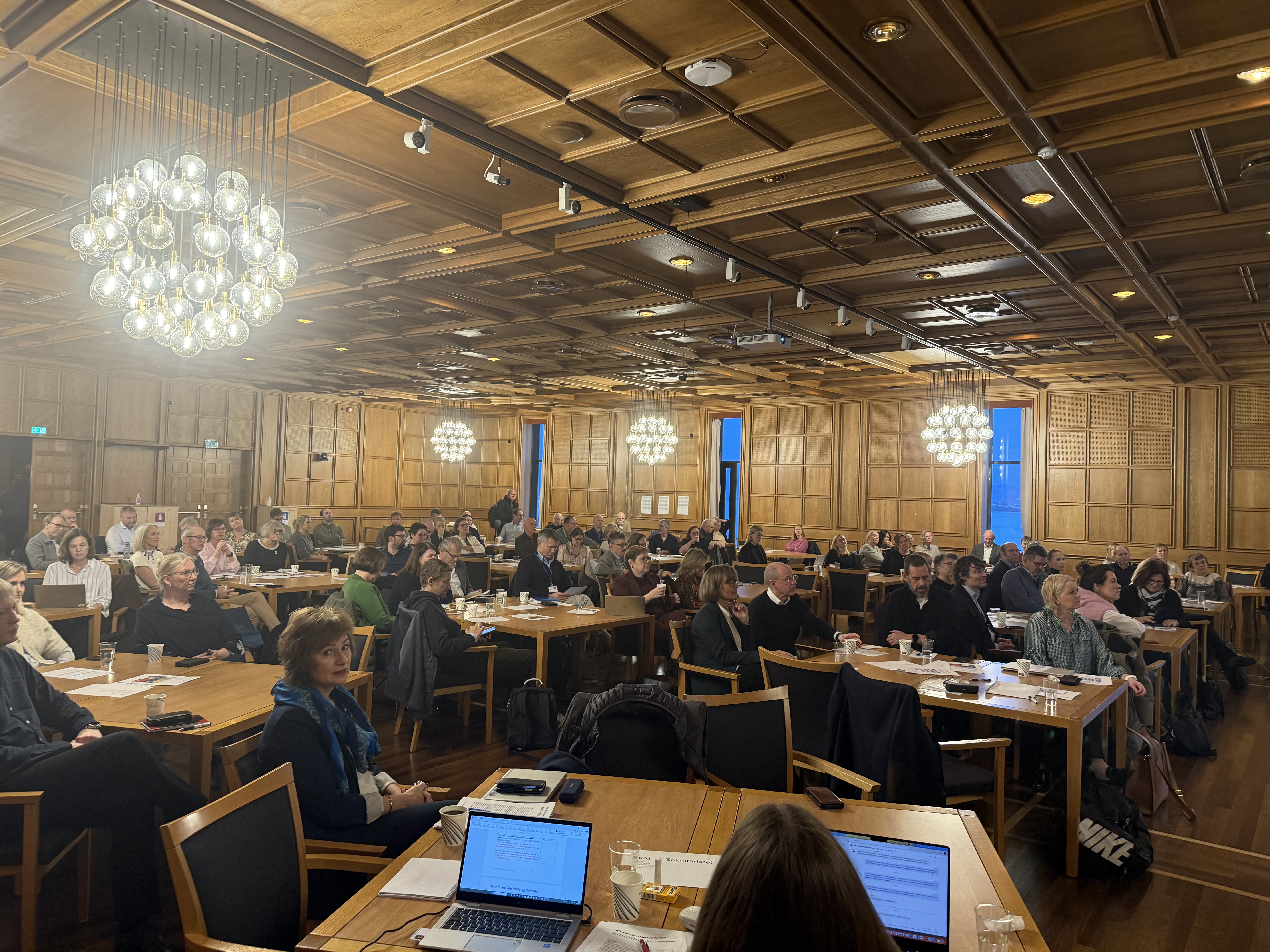 Konferansesal med over 100 deltagere rundt mange bord.