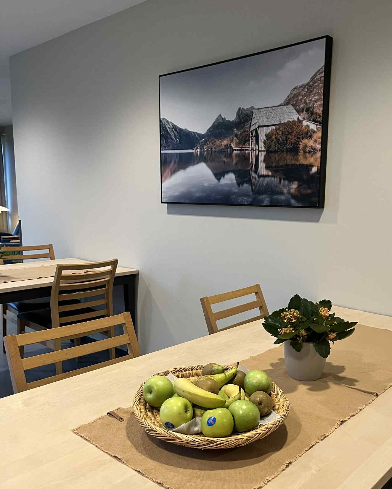 Spisebord med stoler, fruktfat og bilde i spiserom