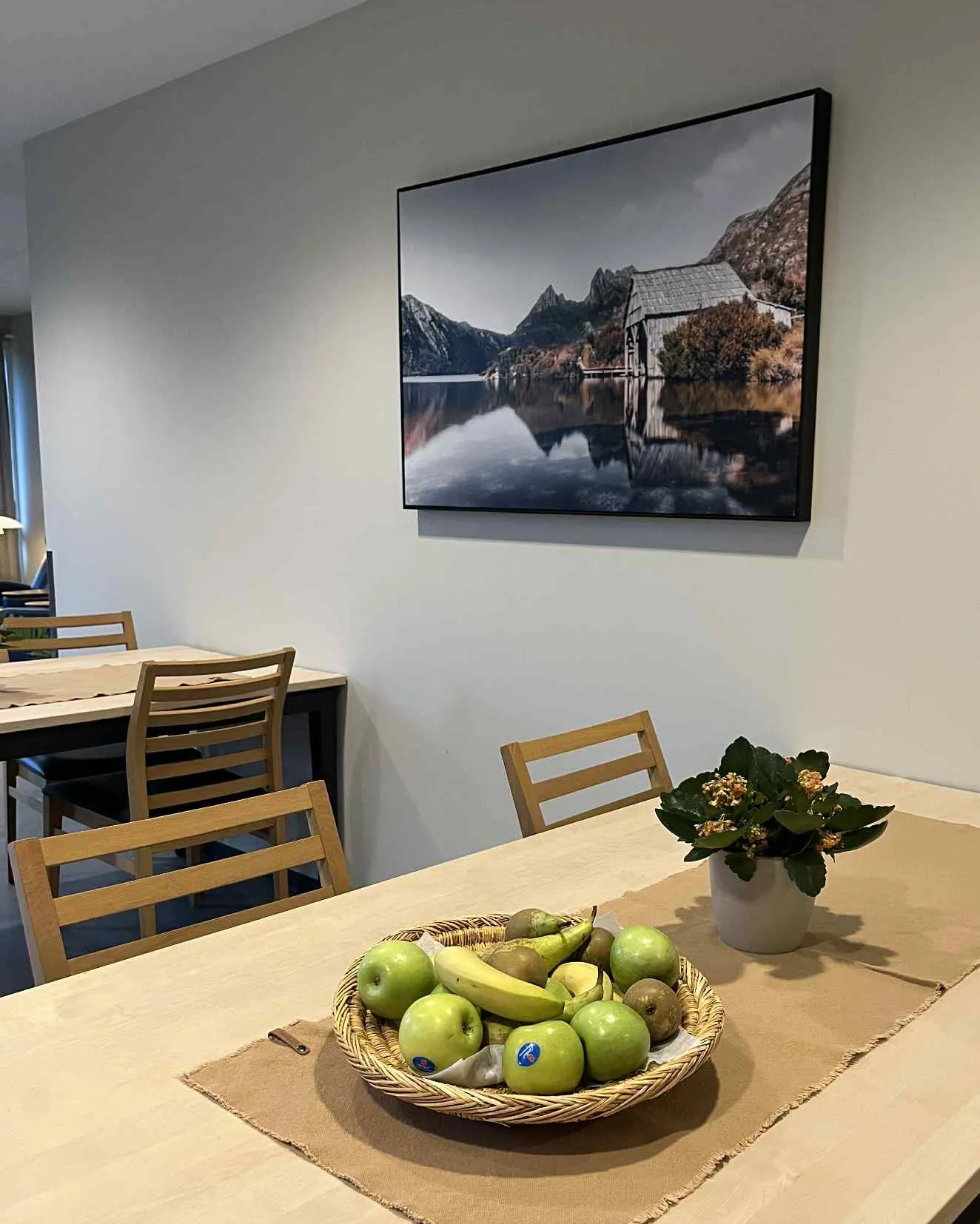 Spisebord med stoler, fruktfat og bilde i spiserom