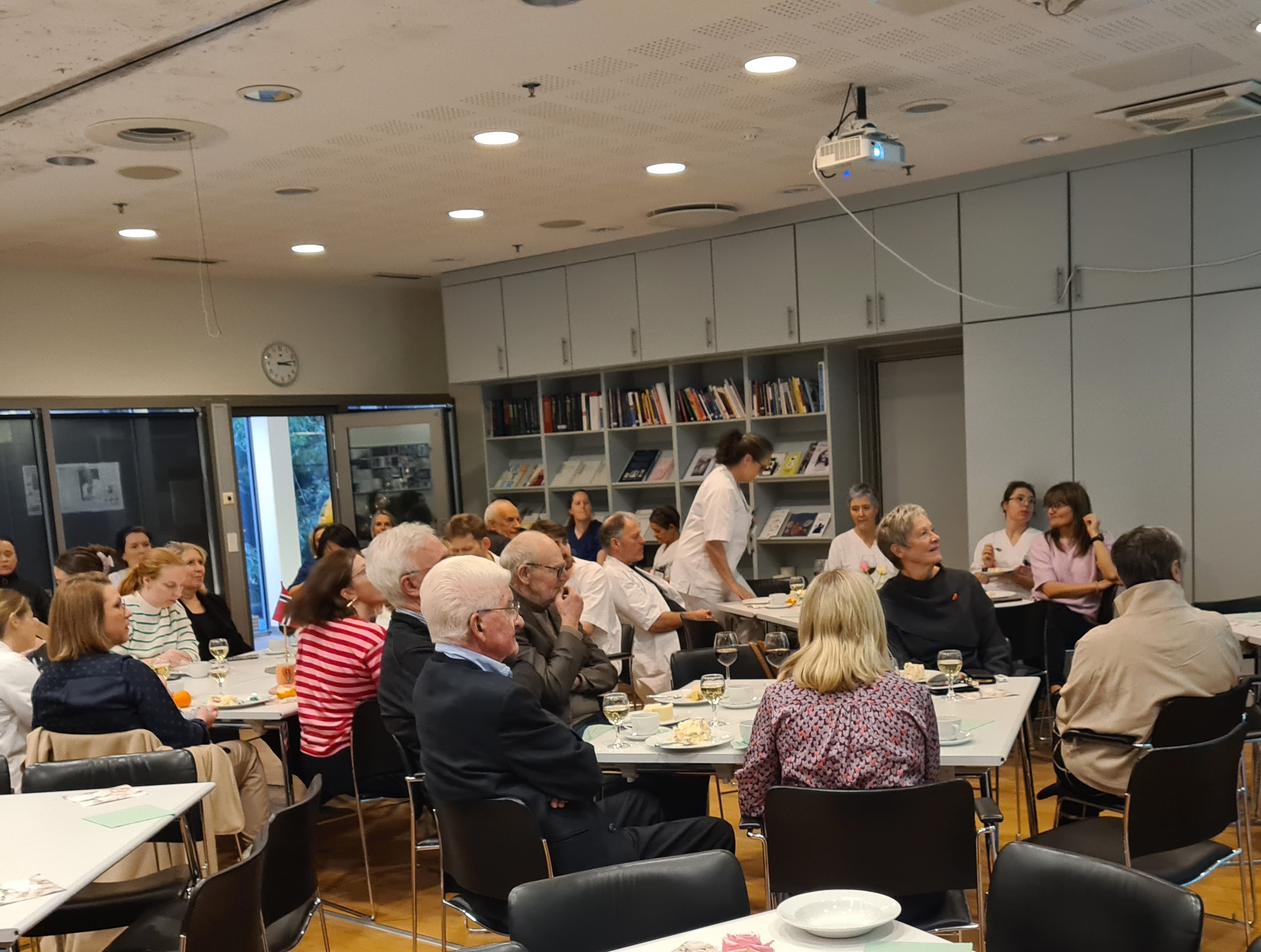 En gruppe mennesker som sitter ved bord