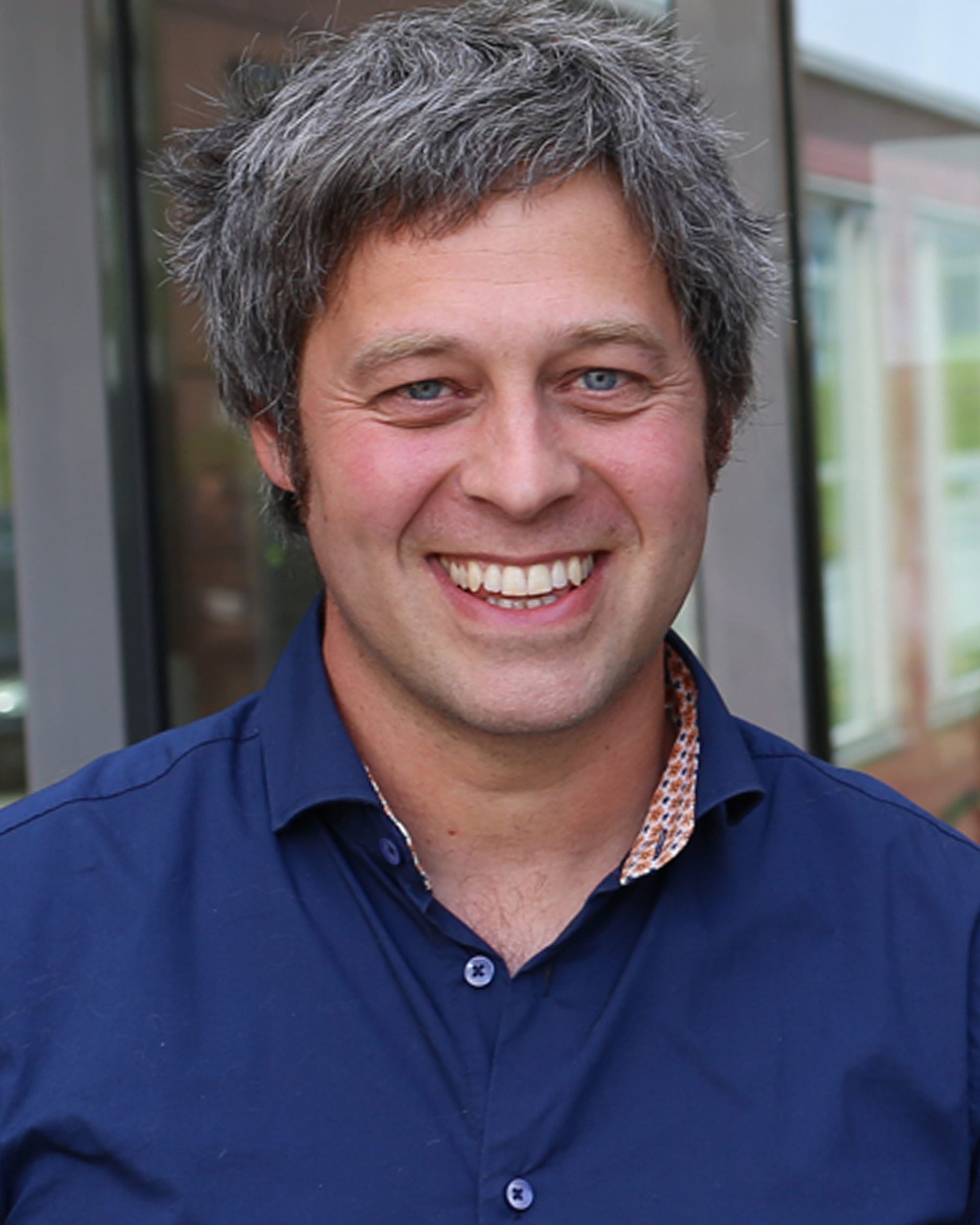 En mann som smiler til kameraet